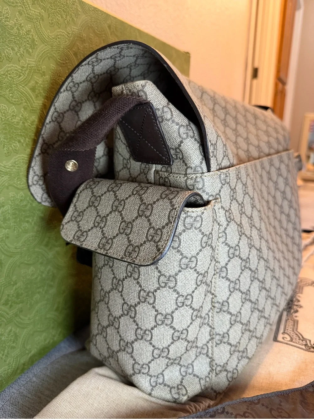 GG Supreme canvas diaper bag, designed with multiple pockets and fold-out pad